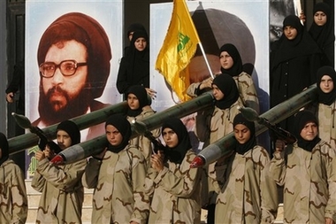 Lebanese Hezbollah women hold model of a Katyusha rockets launchers in front of a portrait of Hezbollah's former Secretary-General Abbas Musawi, who was killed in an Israeli helicopter gunship attack in southern Lebanon in 1992, during a rally in Saksakkiyeh village, southern Lebanon, Sunday July 22, 2007.