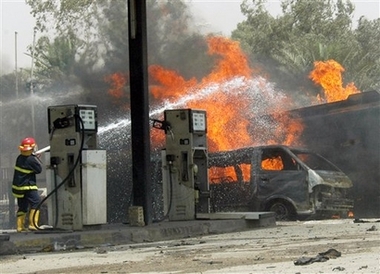 Firemen extinguish a fuel tanker that exploded near a gas station in the primarily Sunni Mansour neighborhood of western Baghdad, Iraq, killing at least 50 people and wounding 60, on Wednesday, Aug. 1, 2007.