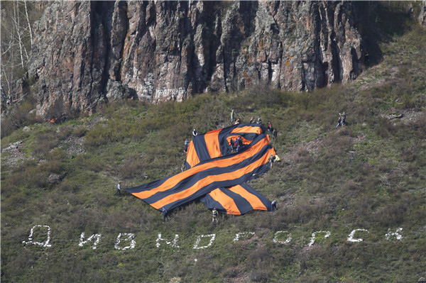 People mark upcoming Victory Day by placing giant St. George's Ribbon