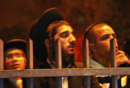 Ultra-Orthodox Jews stand near the scene of a shooting attack in Jerusalem March 6, 2008. A Palestinian gunman opened fire in a Jewish religious school in Jerusalem on Thursday, killing at least eight people and wounding about 10 in the most lethal attack in Israel in two years, emergency services said. [Agencies]