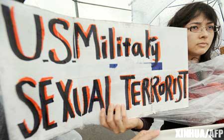 A protestor holds a banner during a rally against an alleged rape in February of a 14-year-old girl by an American serviceman in Okinawa islands, southwestern Japan, Sunday, March 23, 2008.