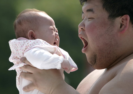 A baby cries as an amateur sumo wrestler tries to scare her during a baby crying contest at Sensoji temple in Tokyo April 27, 2008. Eighty babies born in 2007 took part in the event, which is held to pray for the babies' health and growth. The winner of the contest is the baby who cries the loudest.
