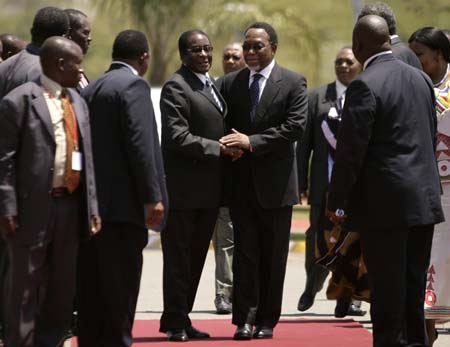 Zimbabwe's President Robert Mugabe (centre L) greets South Africa President Kgalema Motlanthe as they arrive for the summit of the Southern African Development Community (SADC) regional group in Mbabane October 20, 2008. Zimbabwean opposition leader Morgan Tsvangirai will not attend a regional summit on Zimbabwe's political crisis, throwing the mediation process into disarray. The meeting of the heads of state of Angola, Swaziland and Mozambique -- who form the security committee of the SADC -- is aimed at trying to help Zimbabwe's political rivals break a deadlock in negotiations on forming a cabinet. 