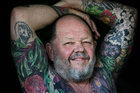 Retired teacher Geoff Ostling displays his tattooed skin at a portrait 