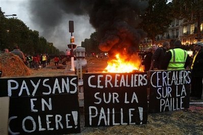 Farmers block Paris' Champs-Elysees, burn hay