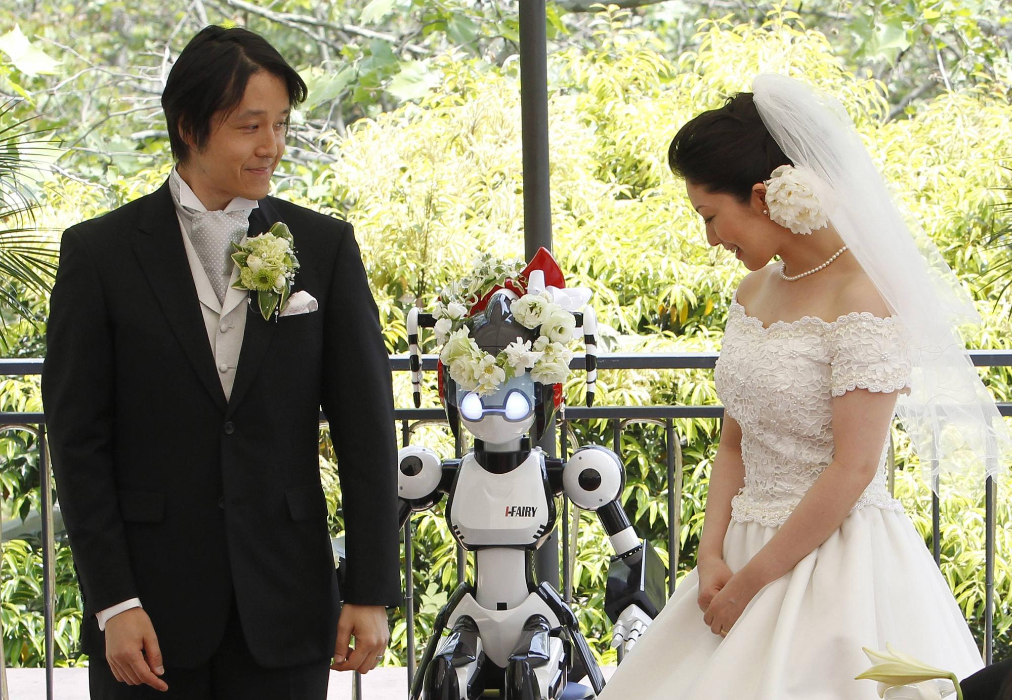 Eyes flashing, robot conducts wedding in Tokyo