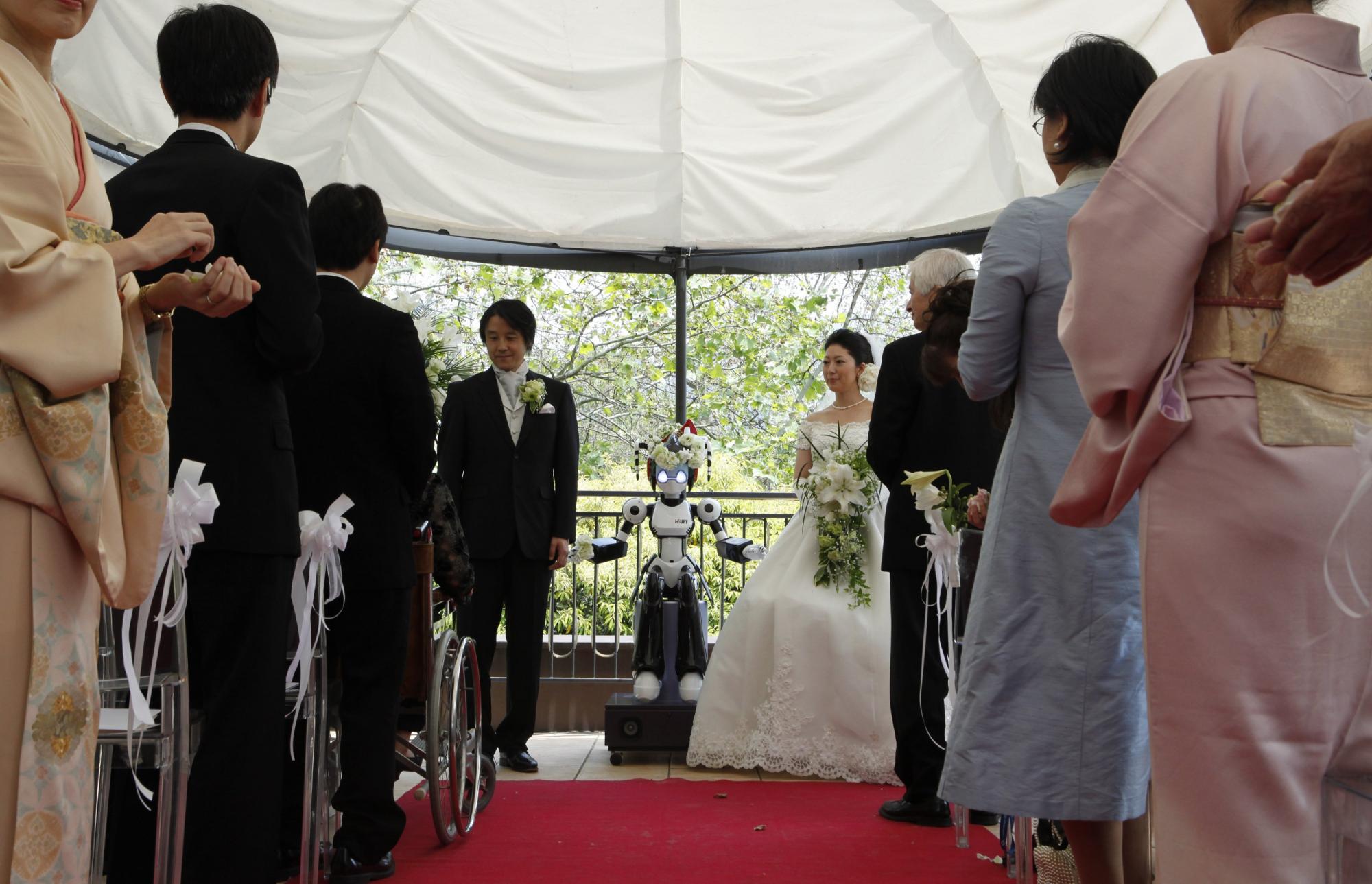 Eyes flashing, robot conducts wedding in Tokyo