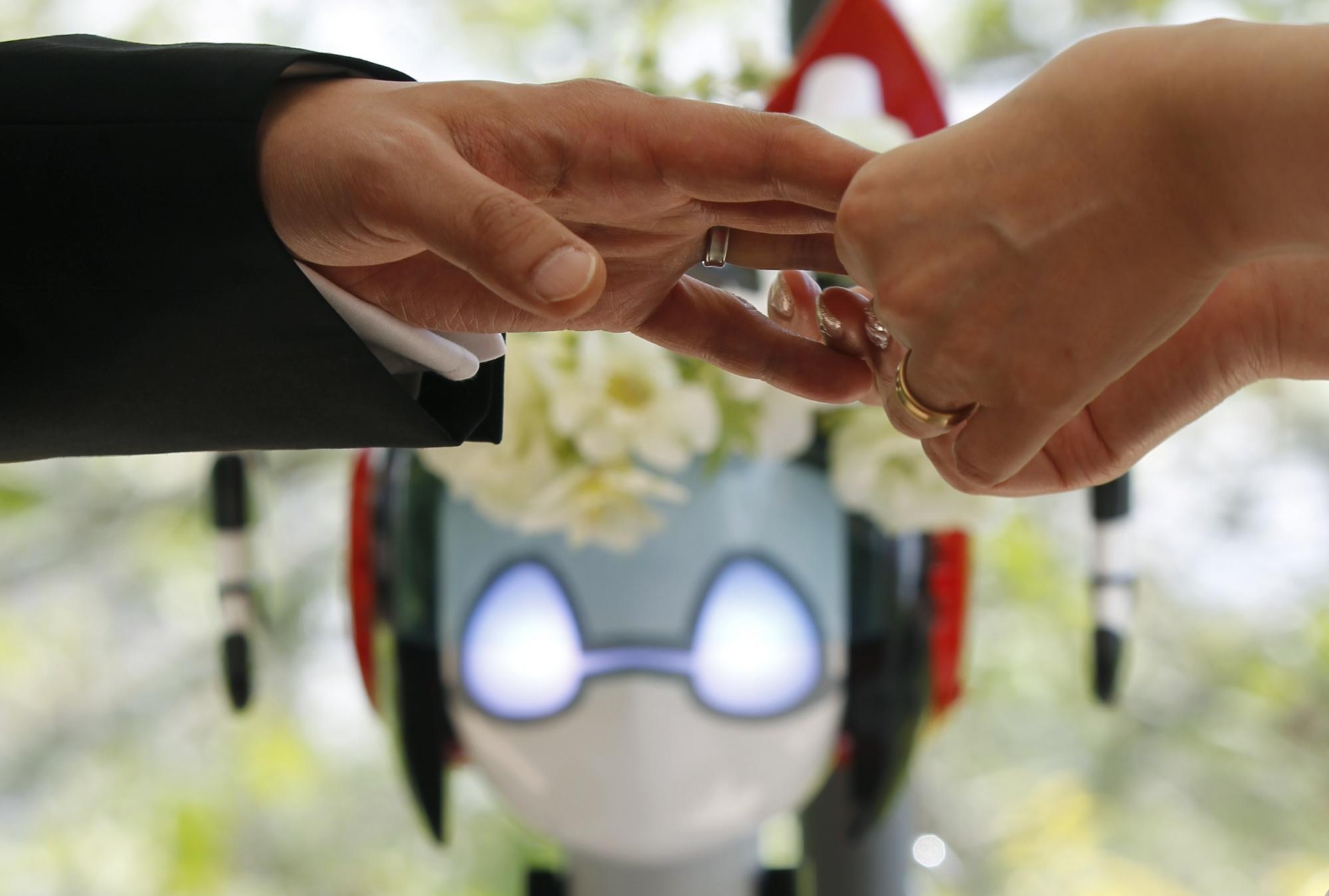 Eyes flashing, robot conducts wedding in Tokyo