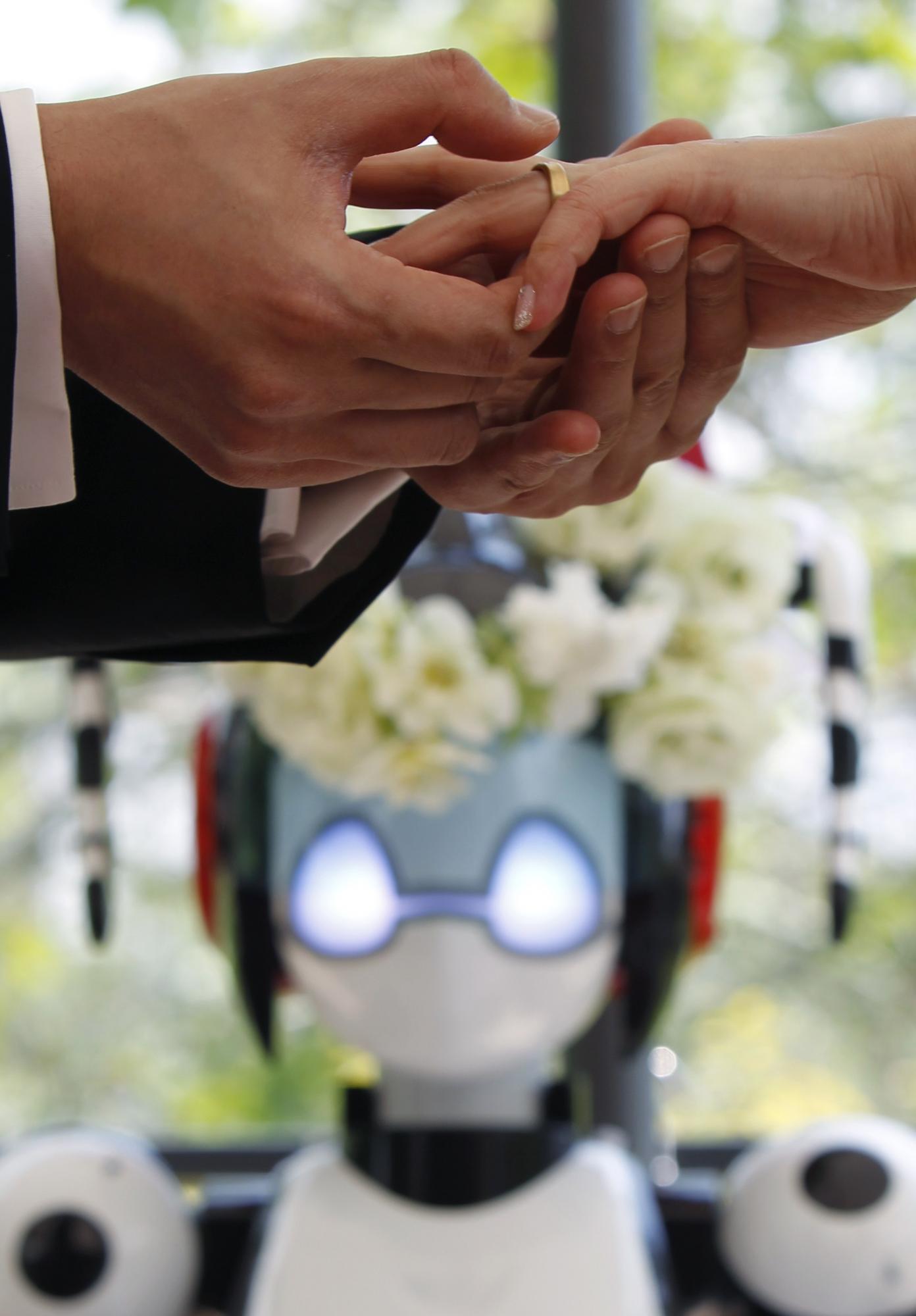 Eyes flashing, robot conducts wedding in Tokyo