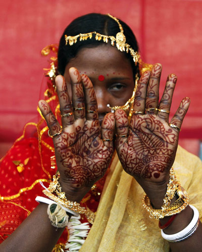 85 tribal Muslim and Hindu couples tie knot A bride shows her hands 