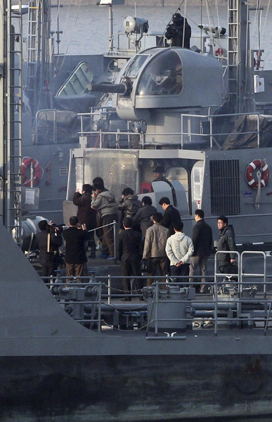 DPRK nationals board a ROK's naval vessel upon their return to DPRK at a naval base in Incheon, west of Seoul March 27, 2011. ROK sends 27 DPRK nationals back home
