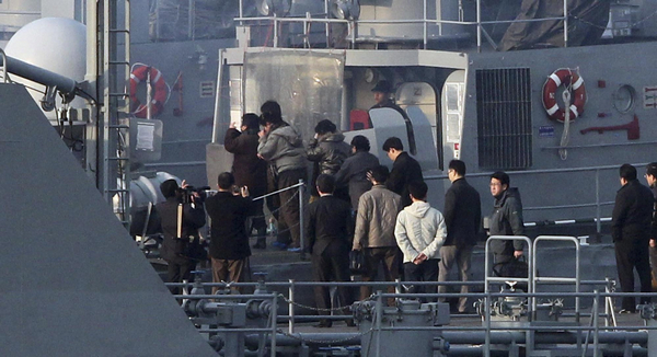 DPRK nationals board a ROK's naval vessel upon their return to DPRK at a naval base in Incheon, west of Seoul March 27, 2011. ROK sends 27 DPRK nationals back home