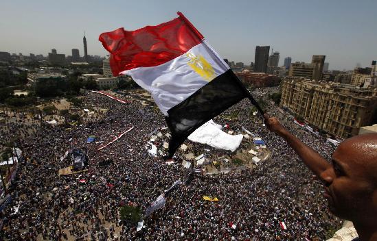 An Egyptian waves a national flag as protesters gather in Tahrir square in Cairo July 8, 2011. Thousands of Egyptians gathered in Cairo's Tahrir Square on Friday to demand faster reforms and the swifter prosecution of former officials from Hosni Mubarak's toppled government who face corruption and murder charges. Egyptians rally to demand faster reforms