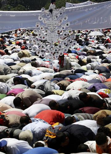 Egyptians take part in Friday prayers in front of a tree map showing names of some Egyptians killed during the February 2011 revolution, at Tahrir Square in Cairo July 8, 2011. Egyptians rally to demand faster reforms