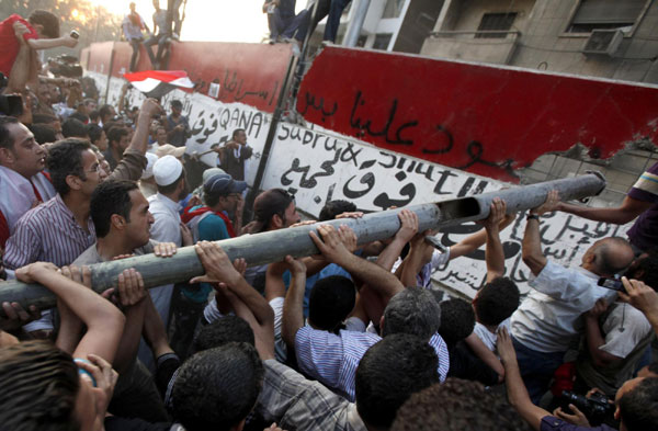 Protesters knock down a concrete wall built in front of the Israeli ...