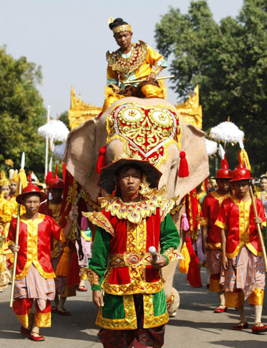 People parade with a white elephant and a vehicle carrying a sacred Buddha tooth relic from China, encircling the grounds of the Maha Pasana Cave in Yangon Nov 22, 2011.