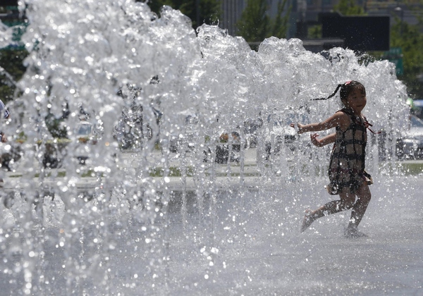 Girl plays at fountain to cool down in Seoul