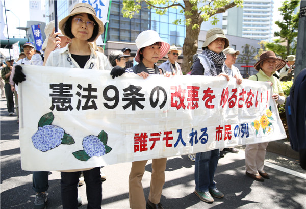 Abe's efforts to revise pacifist constitution encounter mass protest at home