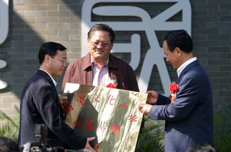 海南省委常委,宣传部长周文彰(右)给海口市委副书记,市长徐唐先授牌.