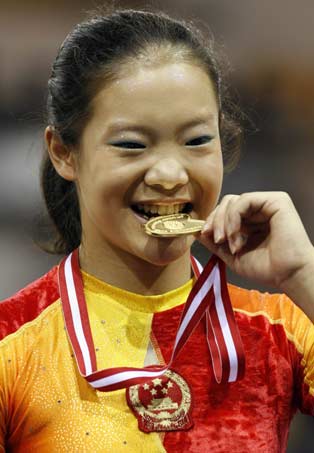 China's floor gold medalist Cheng Fei bites on her medal following the podium ceremony at the 39th Artistic Gymnastics World Championships in Aarhus, Denmark October 21, 2006. 