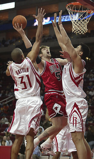 Chicago Bulls center Ben Wallace (R) strips the ball from Houston Rockets center Yao Ming with the help of teammate Kirk Hinrich during the first half of their NBA game in Houston November 16, 2006.