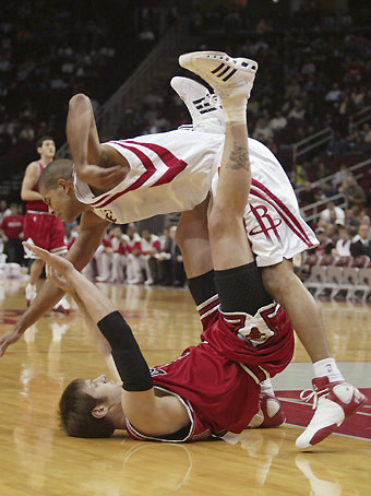Chicago Bulls center Ben Wallace (R) strips the ball from Houston Rockets center Yao Ming with the help of teammate Kirk Hinrich during the first half of their NBA game in Houston November 16, 2006.