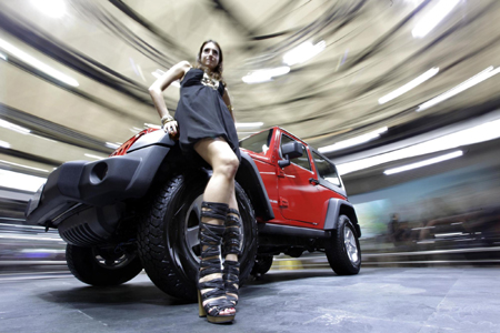 A model stands next to a Jeep Rubicon