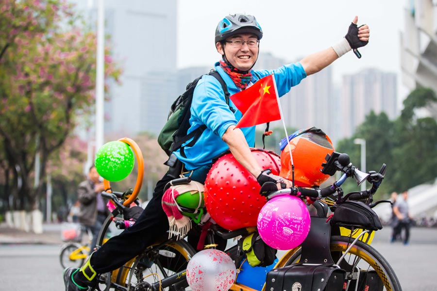Cyclists sit back as they pedal through Guangzhou