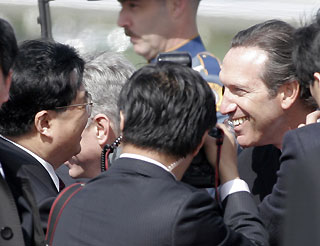 President Hu Jintao (L) greets Starbucks' CEO Howard Schultz (R) after arriving at Paine Field in Everett, Washington, April 18, 2006.