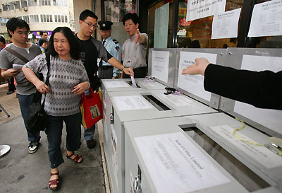 Investors put application forms into the collection box for the initial public offering of Bank of China before the deadline in Hong Kong May 23, 2006. Bank of China is expected to price its IPO, worth up to $9.8 billion, at or near the top of its indicated range, but turbulent global markets could have curbed retail oversubscription levels. 