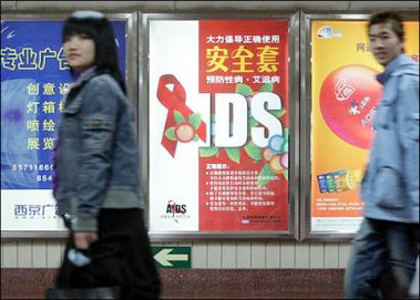Chinese commuters walk pass an anti-AIDS campaign poster at a subway station in Beijing. China is emerging from the shadows of the AIDS pandemic by improving its accounting of the number of cases within the country, the UN agency spearheading the fight against the disease said.(AFP