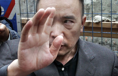 Smuggling kingpin Lai Changxing, one of China's most wanted fugitives, gestures while talking to media outside his residence in Vancouver, British Columbia June 1, 2006. A Canadian judge ruled on Thursday to delay the planned deportation of Lai.[Reuters]