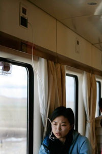 A passenger wears an oxygen tube on board the first Beijing-to-Lhasa train as it cruises along the Qinghai-Tibet railway July 3, 2006. Many passengers were affected by high-altitude problem as the train passed over 4,500 metres. [Reuters]