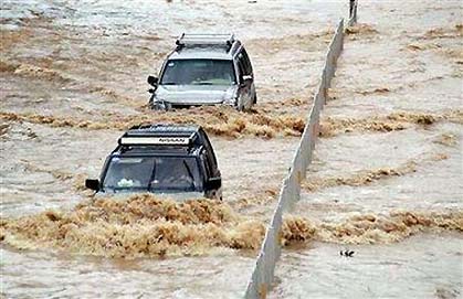 Vehicles make their way on a flooded street in Fuzhou, China's Fujian province, July 16, 2006.