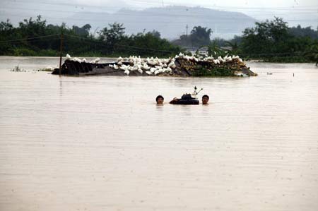 Chinese soldiers rescue people in flood in Shaoguan, South China's Guangdong Province, July 16, 2006. [Fang Qianhua/Southern Daily]