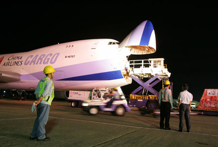 Airport workers load up a cargo plane from China Airlines, Taiwan's largest air carrier, at Taiwan international airport in Taipei July 19, 2006. Taiwan's first non-stop cargo charter flight to Chinese mainland will take off for Shanghai on Wednesday, taking full direct transport links a step closer between two economies across the Straits. [Reuters] 