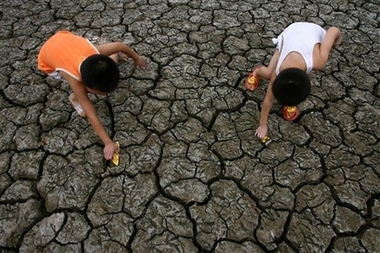 Two children play in a dried-up pool at Xiniushi Village in Daying County of Suining City, southwest China's Sichuan Province, Sunday, Aug. 13, 2006. Most areas of Sichuan Province have been suffering from month-long drought and searing heat. Local governments have allocated funds to help residents fight against drought by tapping ground water and improving water conservation facilities. [Zhong Min/Xinhua] 