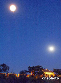 Two "moons" shine in the sky over Marco Polo Bridge in southwest Beijing, on Thursday evening. One of them is an artificial moon, designed to relive a famous ancient scene called "Morning Moon over Marco Polo Bridge"