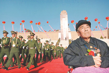 Veteran Red Army soldier Li Zhanrong, 86, sits in front of the Long March Monument at Jiangtaibao of Xiji County in Northwest China's Ningxia Hui Autonomous Region yesterday. The Long March ended at Jiangtaibao on October 22, 1936, after which the Red Army headed to Yan'an where the new CPC headquarters was established. (Xinhua)