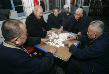 Elderly men play mahjong at a nursing home in Beijing December 11, 2006. China will face a crisis in caring for its elderly unless it can shore up its inadequate and mismanaged social security funds before an explosion in its rapidly ageing population, the government said on Tuesday. 