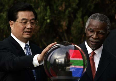 Chinese President Hu Jintao (L) and South Africa's President Thabo Mbeki touch a crystal ball to launch the China South Africa economic trade and cooperation website at the Union building in Pretoria February 6, 2007. [Reuters]