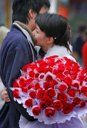 A Chinese woman hugs her boyfriend after receiving a bunch of roses during Valentine's Day in Nanjing, capital of east China's Jiangsu province February 14, 2006. 