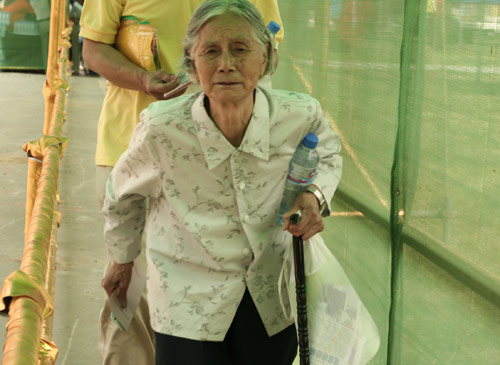 An aged woman waits to cast a vote on the demolishment and reconstruction of old buildings in Juixiaqiao Sub-district in Beijing, June 9, 2007. Local government and the real estate developer jointly organize the vote on Saturday to see if majority residents of over 5000 families accept the new compensation policy after failed attempts to reach an agreement through other ways. Both notary officials and supervisors are invited to monitor the vote that runs from 9 a.m. to 9 p.m. at six ballot booths. [Sun Yuqing/www.chinadaily.com.cn]