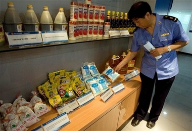 An officer from the Beijing Administration for Industry and Commerce (BAIC) office look at fake or non-standard products on display at a BAIC food safety monitoring center in Beijing Tuesday, June 12, 2007.