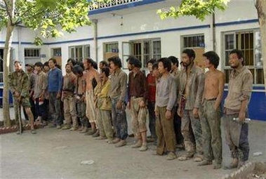 Workers stand at a police station after they were rescued from a brickworks in Hongdong County in Linfen, north China's Shanxi province, May 27, 2007. 