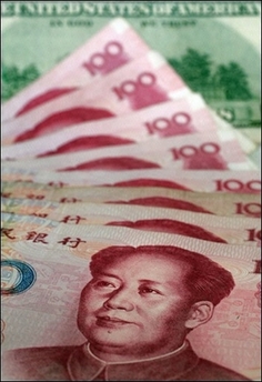 The Chinese currency 100 renminbi (yuan) notes, fronted with an image of former Communist Party chairman Mao Zedong, in contrast with a US$100 note in Beijing. China is not intentionally manipulating its currency to gain an unfair trade advantage but its massive buildup of foreign reserves raises risks for the global economy, a US government report said Wednesday.(AFP