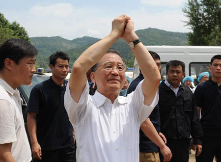 Chinese Premier Wen Jiabao greets local people during an inspection in Muyu Township of Qingchuan County, one of the worst-hit area of Guangyuan City in southwest China's Sichuan Province, May 15, 2008. Wen is here to oversee rescue work and visit survivors.(Xinhua/Tao Ming)