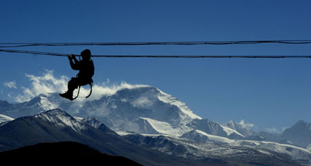 Worker repairs power lines in Tibet