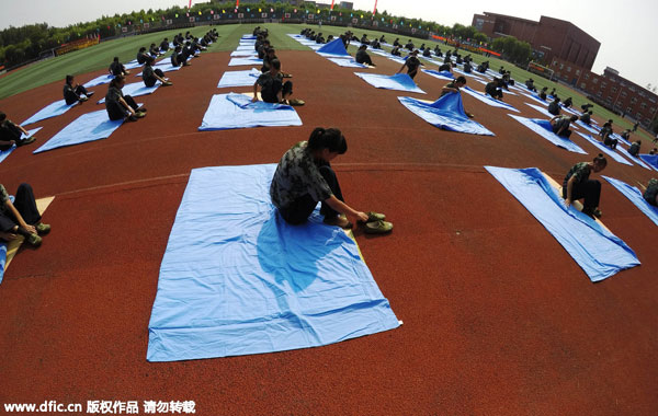 Freshmen fold quilts in 80 sec during military training