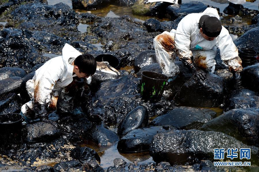 Workers clean up leaking oil on seaside of New Taipei city
